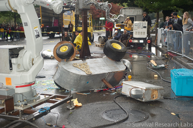Blender Bot is dismembered and decapitated by the Motoman.  Spine Robot in the background